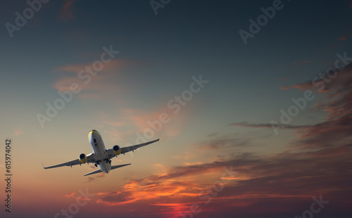 Commercial airliner taking off or landing against dramatic red blue sky - with landing gear halfway out