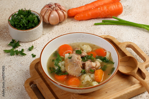 Homemade chicken soup with vegetables in a white bowl.Healthy warm comfortable food.
