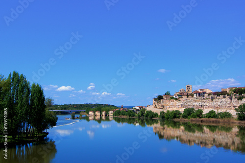 View on Old Town of Zamora from Bridge Puente de Piedra across River Douro with Water Reflection in Sunny Day. Zamora, Castilla and Leon, Spain