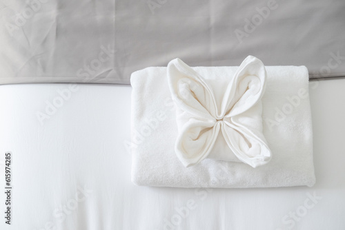 Top view of white fresh towel on bed in bedroom in the hotel