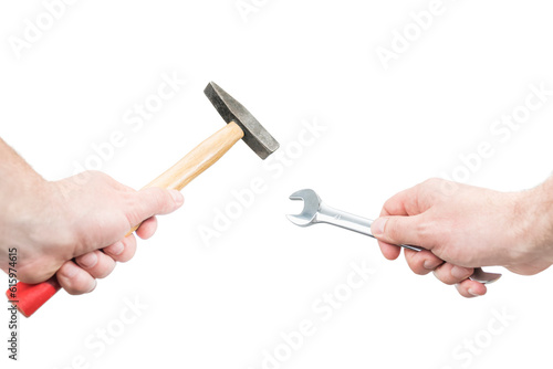 Male hands holding a hammer and a wrench, close-up, isolated on a white background, first-person view