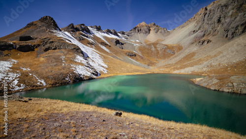 Island Lake: emerald green water under clear, blue sky with snow on mountain | San Juan National Forest, Colorado, USA photo