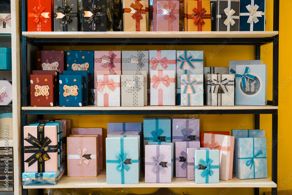 Colorful and patterned gift box stacks arranged on multi-tiered shelves