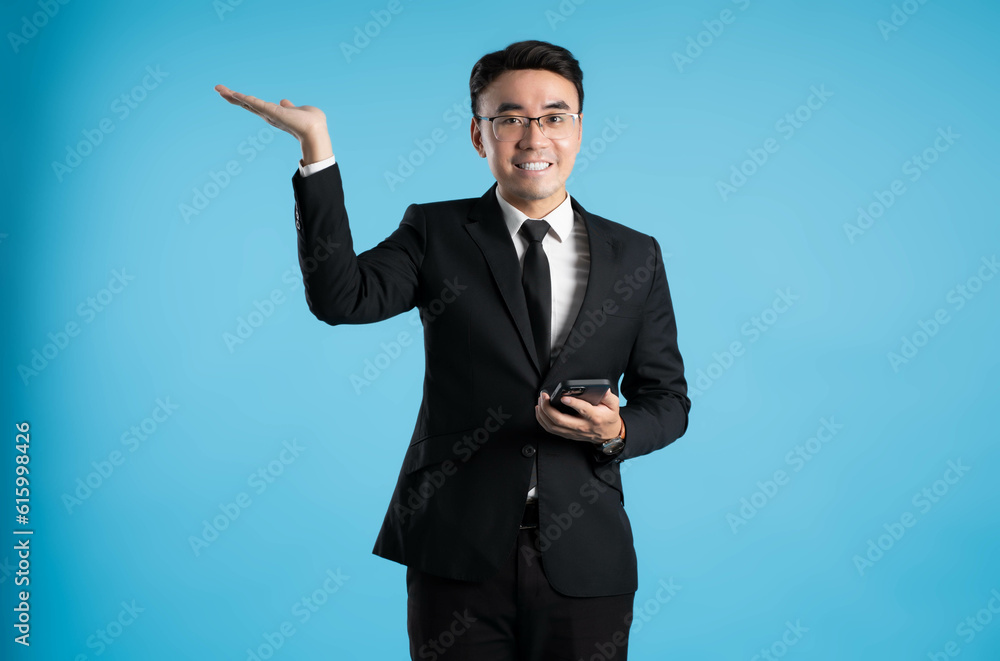 image of young businessman using phone on blue background image of young businessman using phone on blue background