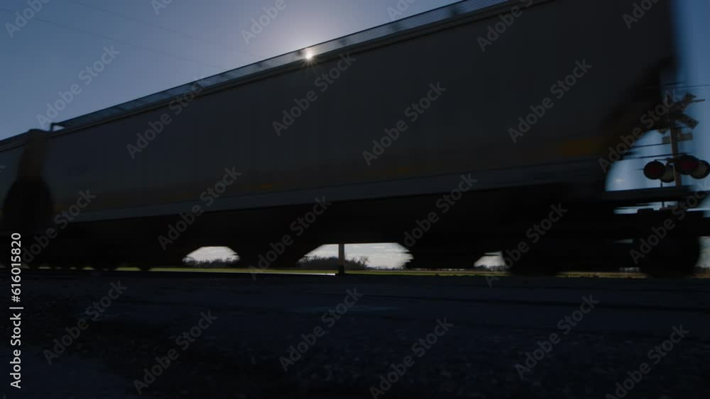Freight Train Passing Through American Farmland at Sunset Freight Train Passing Through American Farmland at Sunset
