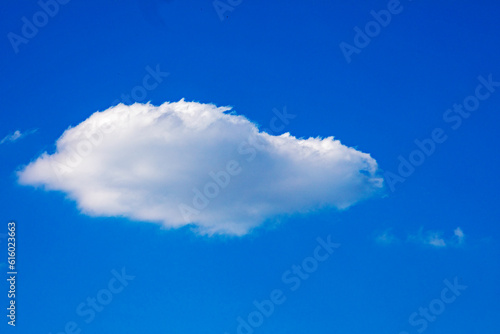 white fluffy cloud against the blue sky, horizontal