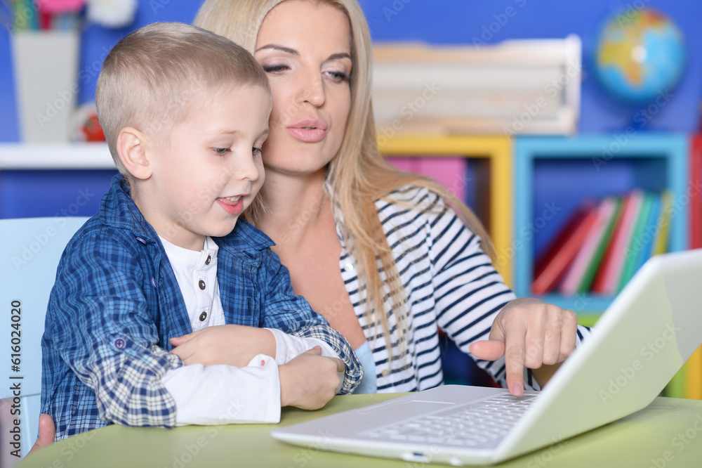 mother and son using modern laptop mother and son using modern laptop