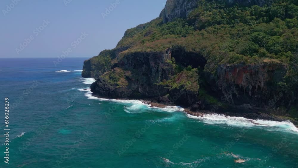 Aerial establishing shot of coastline in Samana with crashing waves of Caribbean Sea at sunlight and blue sky - orbit flight Aerial establishing shot of coastline in Samana with crashing waves of Caribbean Sea at sunlight and blue sky - orbit flight