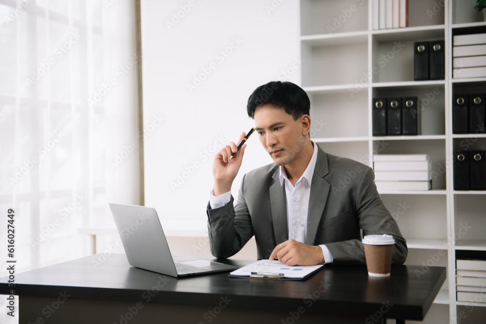Confident Asian man with a smile standing holding notepad and tablet at the modern office. Confident Asian man with a smile standing holding notepad and tablet at the modern office.