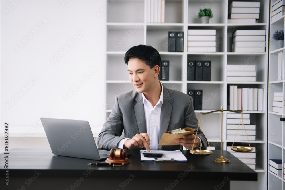 justice and law concept. Asian businessman or lawyer or accountant working on accounts using a smart phone laptop digital tablet calculator and documents justice and law concept. Asian businessman or lawyer or accountant working on accounts using a smart phone laptop digital tablet calculator and documents