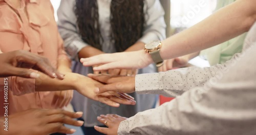 Midsection of diverse businesswomen stacking hands at office, in slow motion
