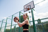 Athletic female basketball player throwing a ball up to the net