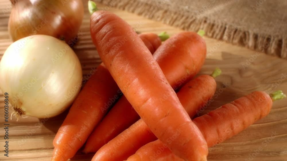 fresh vegetables. carrots and onions on a wooden background. harvest on the table. smooth camera zoom. sunny day. High quality 4k footage fresh vegetables. carrots and onions on a wooden background. harvest on the table. smooth camera zoom. sunny day. High quality 4k footage