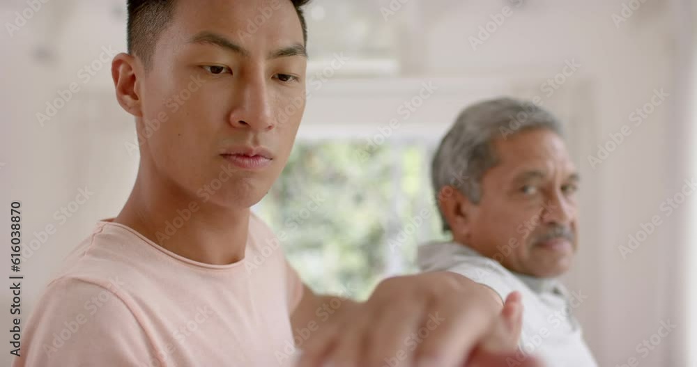 Diverse male physiotherapist advising and senior male patient stretching, in slow motion Diverse male physiotherapist advising and senior male patient stretching, in slow motion