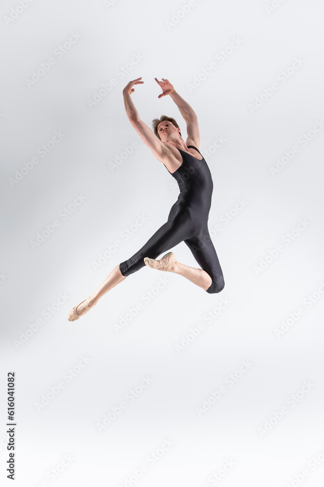 Professional Ballet Dancer Young Caucasian Athletic Man in Black Suit Posing Dancing in Studio On White.