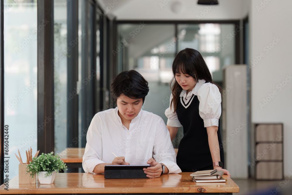 Young entrepreneur couple working on a tablet at cafe. Small business management concept Young entrepreneur couple working on a tablet at cafe. Small business management concept