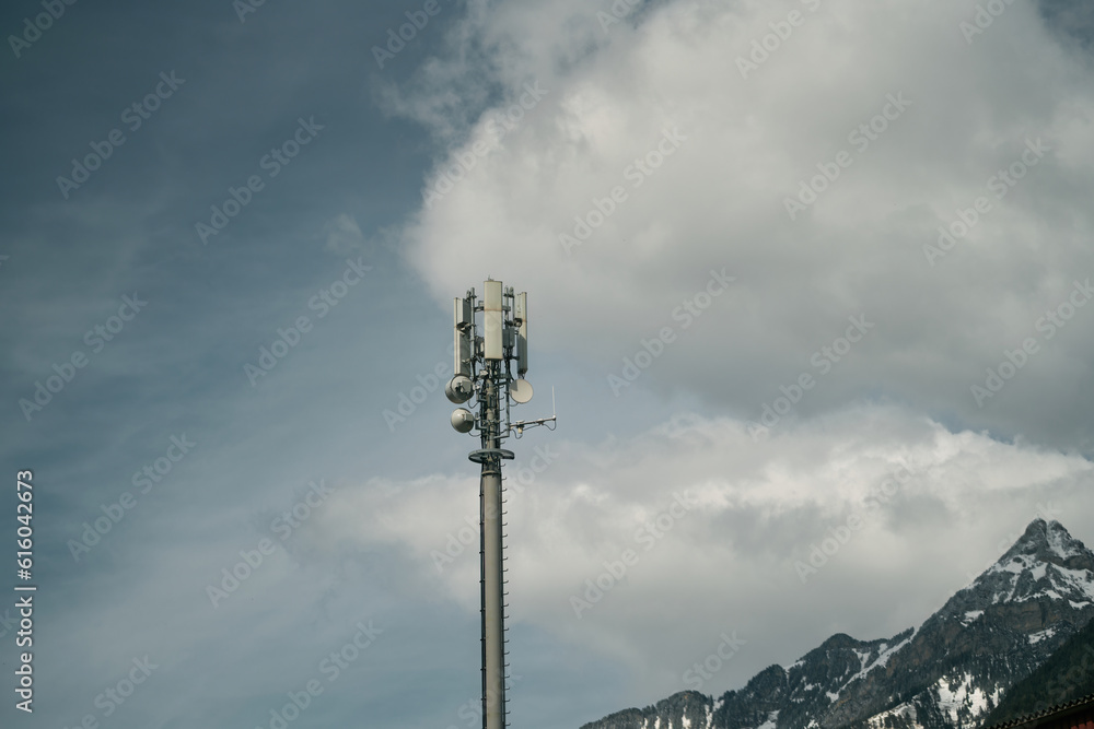 Obraz premium Telecom Tower 5G and 4G Cellular Networks in the sky. cell tower over a forested rural area