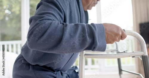 Wallpaper Mural Mid section of biracial senior man using walking frame at home, slow motion Torontodigital.ca