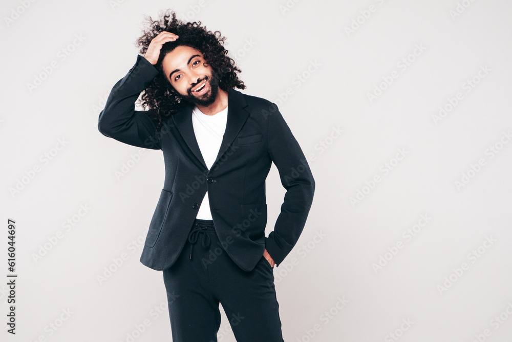 Handsome smiling hipster model. Unshaven Arabian man dressed in summer suit jacket clothes. Fashion male with long curly hairstyle isolated on white in studio. Cheerful and happy Handsome smiling hipster model. Unshaven Arabian man dressed in summer suit jacket clothes. Fashion male with long curly hairstyle isolated on white in studio. Cheerful and happy
