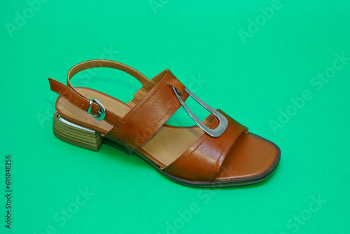 Women's brown leather shoes. casual shoes, fashionable sports city walking shoes. close-up of the front and side. On a GREEN background. 