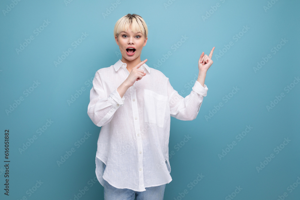 young surprised blond career woman in white shirt on blue background with copy space. people lifestyle concept young surprised blond career woman in white shirt on blue background with copy space. people lifestyle concept