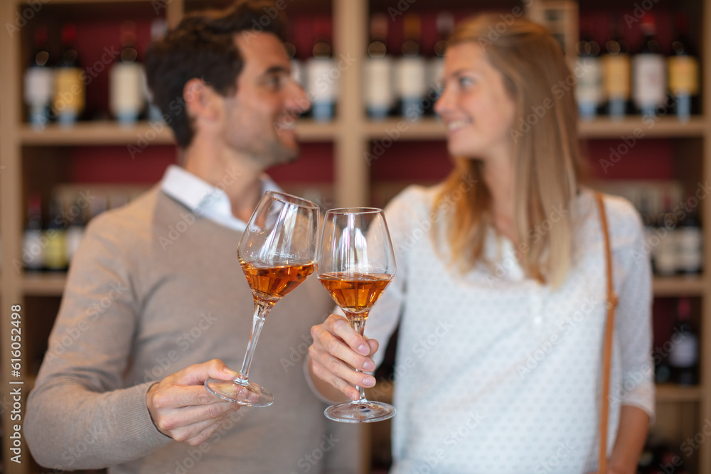 couple clinking glasses in wine shop
