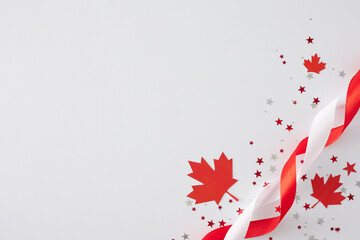 Victoria Day festivities concept in Canada. Top view flat lay of red maple leaves, stars confetti, satin ribbons on white background with empty space for text or greeting