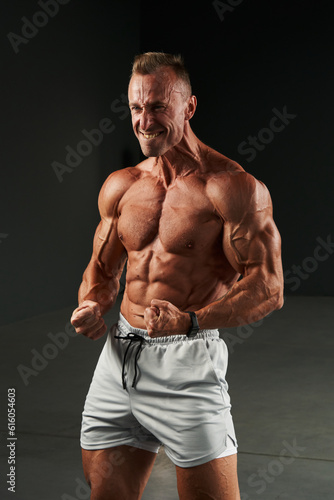from strong tension in the Caucasian athlete, large veins appeared on his arms and neck. ideal muscles of the male press, shoulders, arms, biceps, triceps, forearms