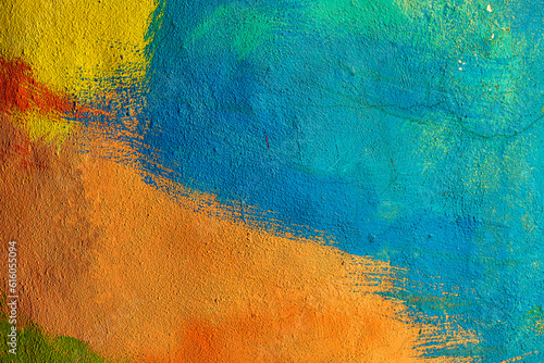 A fragment of colorful graffiti painted on a wall. Abstract urban background. Spray painting art.