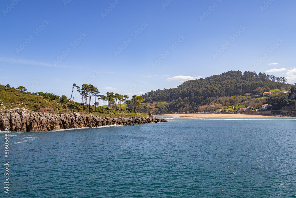 Lekeitio beach and little island of San Nicolas in Basque country, hills and forests around