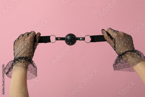 Sex toy gag in female hands in tulle gloves photo