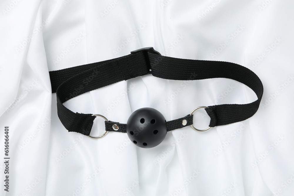 Sex toy gag on a white silk background Sex toy gag on a white silk background