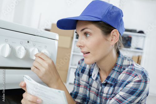 woman setting up cooker holding instruction manual