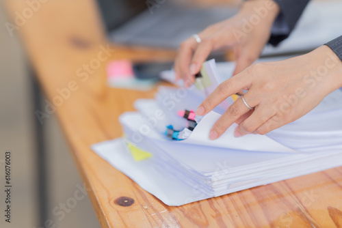Business Documents concept : Employee woman hands working in Stacks paper files for searching and checking unfinished