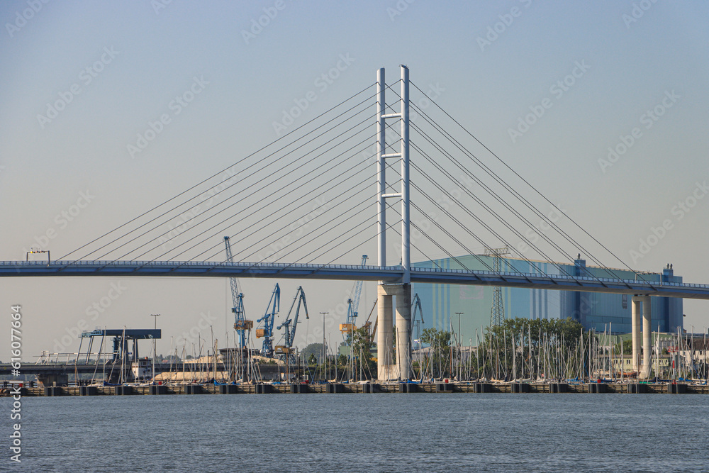 Naklejka premium Hansestadt Stralsund; Neue Rügenbrücke und alter Rügendamm vor Hafen und Werft