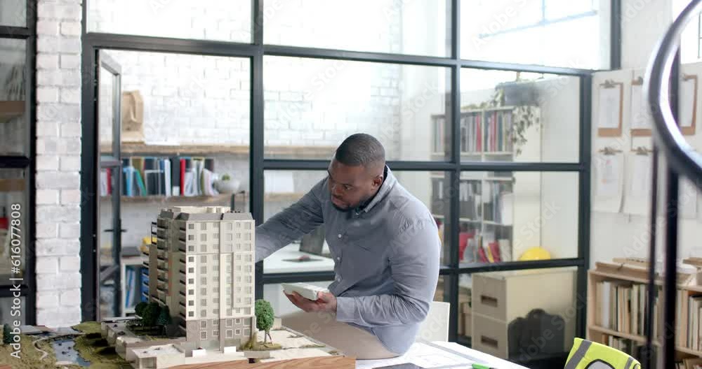 Focused african american casual businessman inspecting city model in office in slow motion Focused african american casual businessman inspecting city model in office in slow motion