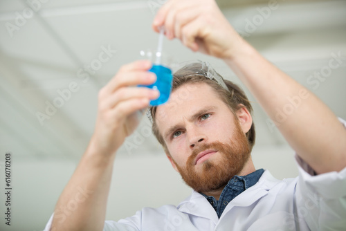 male scientist stirring liquid in a flask