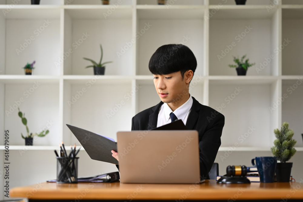 Asian businessman checking marketing research results or statistics data on laptop at his office desk Asian businessman checking marketing research results or statistics data on laptop at his office desk