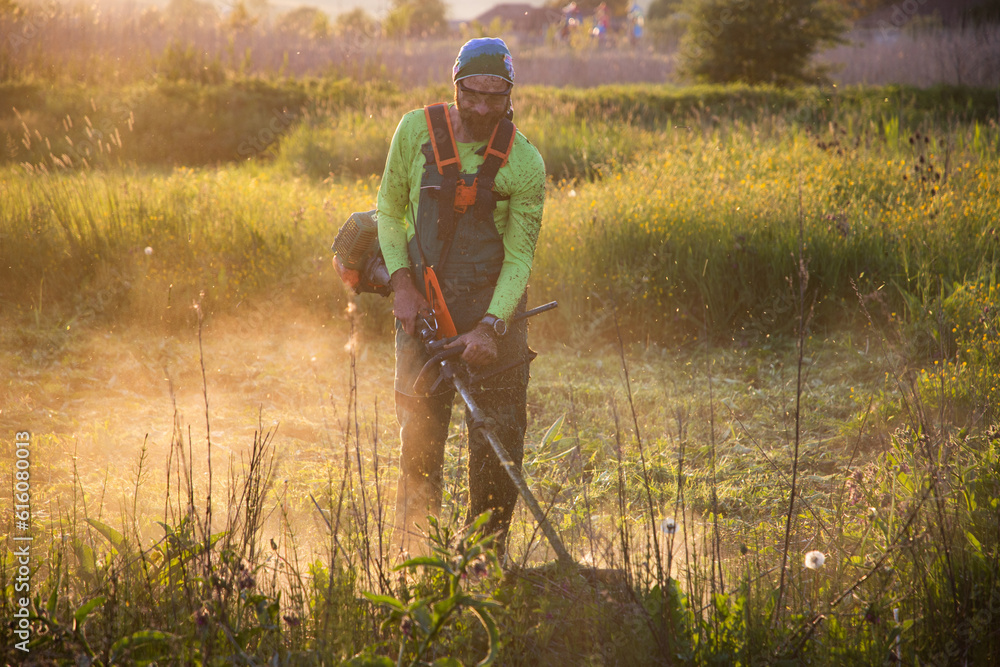man moving the grass at sunset man moving the grass at sunset