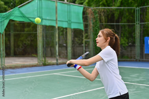 Athlete young woman hitting ball with racket during match. Fitness, sport, exercise concept