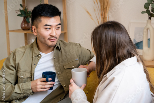 Old friends catching up sitting on the living room couch.