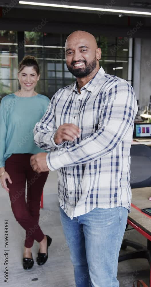 Vertical video of two happy diverse creative designers in discussion in casual office, slow motion Vertical video of two happy diverse creative designers in discussion in casual office, slow motion