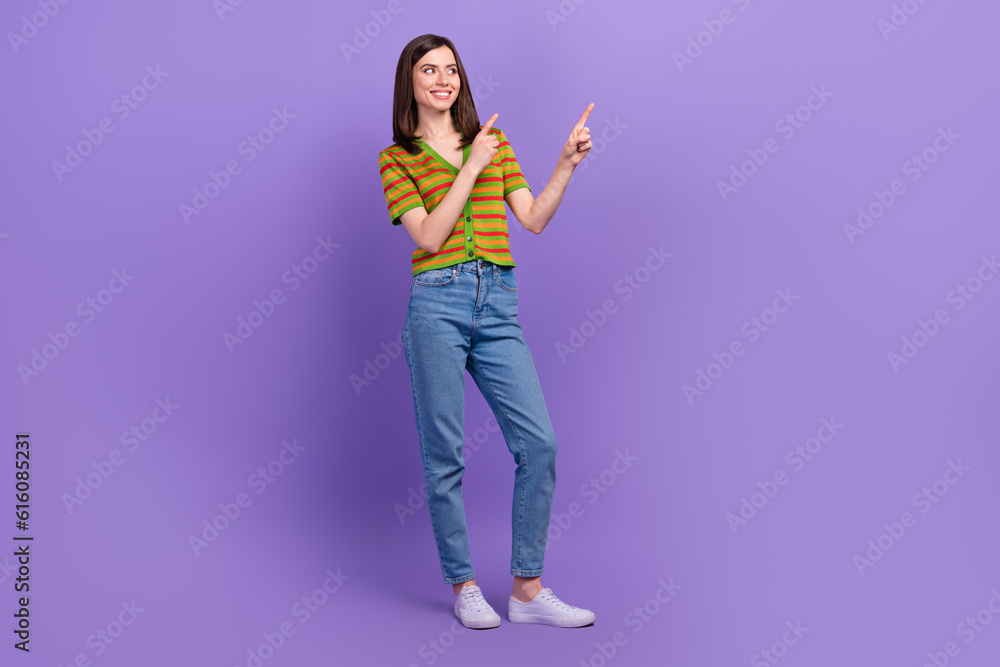 Full length photo of cheerful adorable lovely lady wear trendy clothes hands demonstrate empty space isolated on purple color background Full length photo of cheerful adorable lovely lady wear trendy clothes hands demonstrate empty space isolated on purple color background
