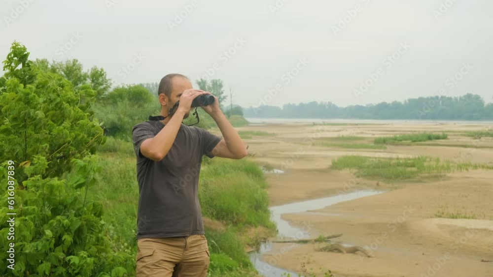 A dried-up reservoir and a young ecologist with binoculars exploring nature. A dried-up reservoir and a young ecologist with binoculars exploring nature.