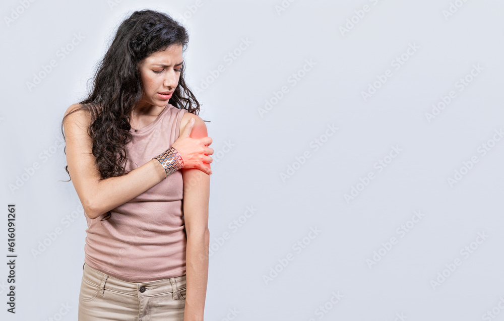 Sore young woman with arm pain isolated. Woman suffering with arm pain, Woman with shoulder and arm pain on isolated background Sore young woman with arm pain isolated. Woman suffering with arm pain, Woman with shoulder and arm pain on isolated background