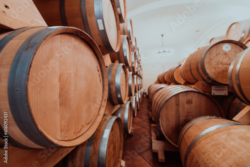 Wine or cognac barrels in the cellar of the winery  Wooden wine barrels in perspective. Wine vaults.Vintage oak barrels of craft beer or brandy. 
