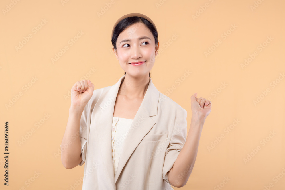 Studio portrait of happy successful confident young asian business woman. Beautiful young lady in white jacket smiling at camera standing isolated on solid beige colour copyspace background Studio portrait of happy successful confident young asian business woman. Beautiful young lady in white jacket smiling at camera standing isolated on solid beige colour copyspace background