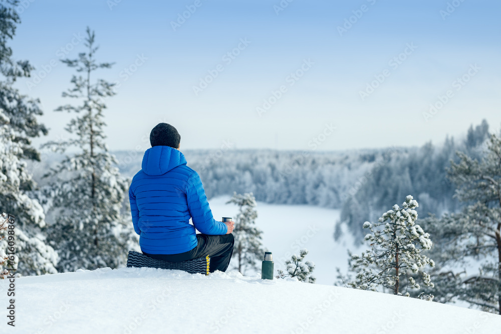 Man relax and waiting for spring in winter forest.