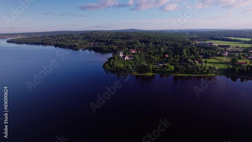 Establishing Aerial dolly shot, view of Christian Rättvik church and houses on the shore of blue siljan lake on sunny summer morning. Swedish landscape scenery in Dalarna County photo