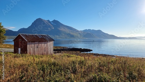 pittoresque hut in beautiful scenery at Norwegian fjord with mountains in the background